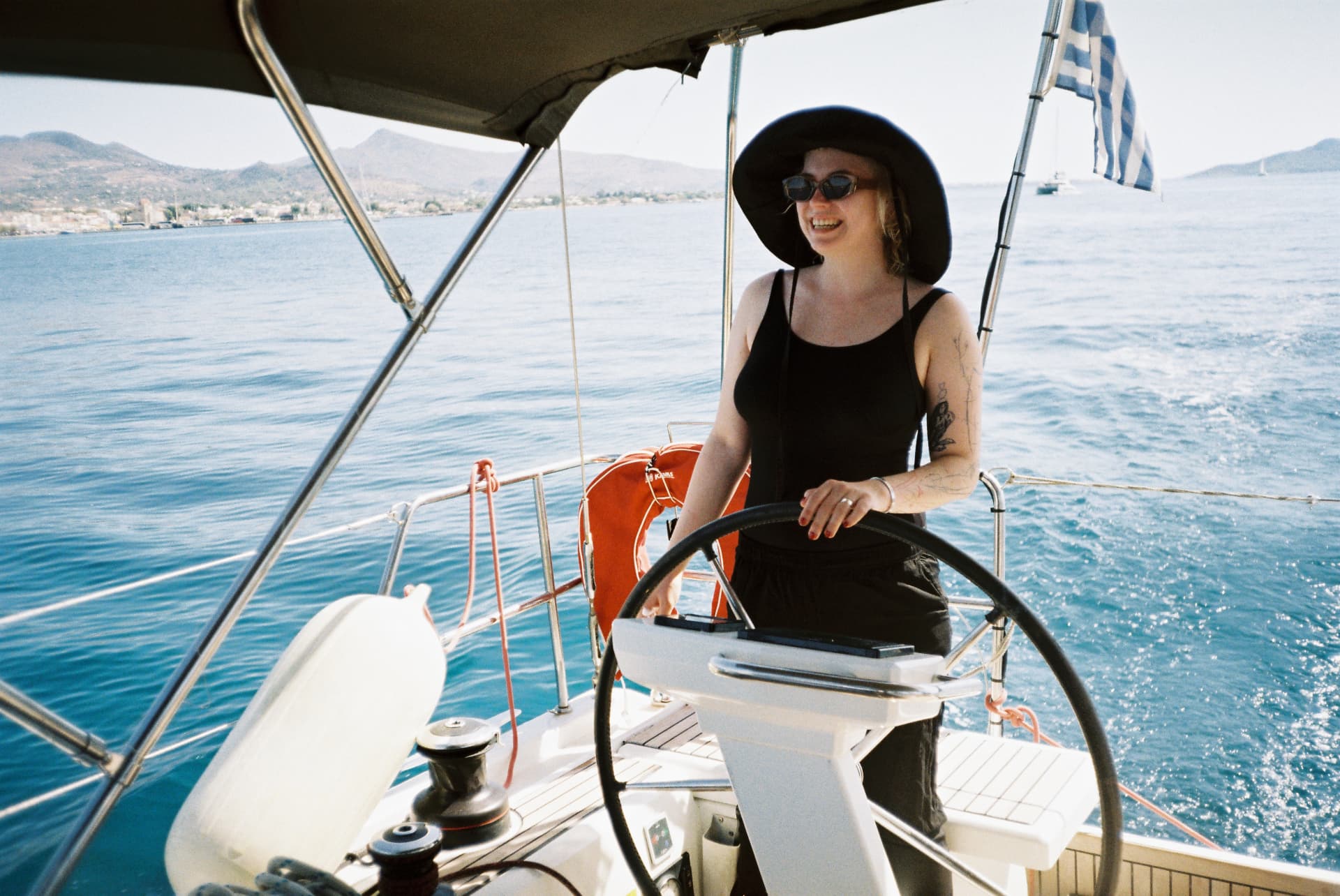 Woman in a black sun hat steering the boat